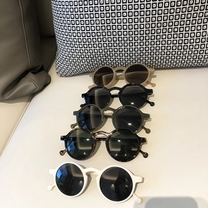 Detail view of round retro sunglasses in beige, black, green and tortoiseshell finishes