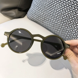 Macro view of retro round olive green sunglasses frame with dark grey polarized lenses