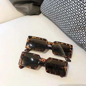 Lunettes de soleil rétro rectangulaires en écaille avec verres foncés sur fond gris