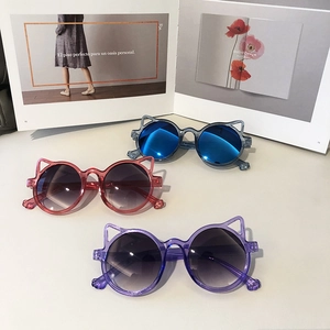 Three pairs of cute cat-ear shaped children sunglasses in blue, pink and purple colors