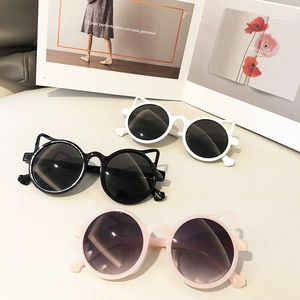 Cat-ear shaped children's sunglasses in black, white and pink colors with round lenses