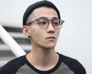 Close-up of stylish grey anti-blue light glasses frames worn outdoors by a model