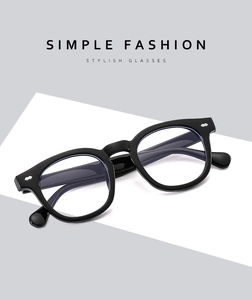 Detail view of black full-rim glasses with stylish silver rivets on a minimalist frame