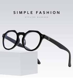 Détail de montures de lunettes noires rondes avec accents de rivets métalliques triples