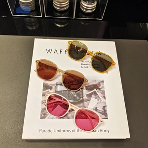 Three pairs of vintage square sunglasses with tortoiseshell and white frames on a book