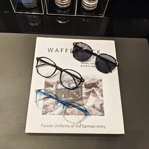 Retro small frame sunglasses and glasses set with metal rivets on black leather background