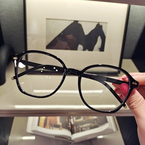 Detail of black small frame sunglasses with gold rivets on temples in a lifestyle setting