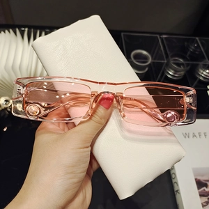 Detail of pink transparent rectangular sunglasses with a beige textured leather case