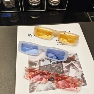 Three pairs of vintage rectangle sunglasses in amber, blue, and pink colors