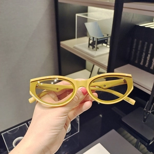 Detailed view of yellow cat-eye sunglasses with retro frame and dark tinted lenses