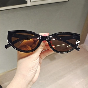 Detailed close-up of retro cat-eye sunglasses with black frame and gold metal accents