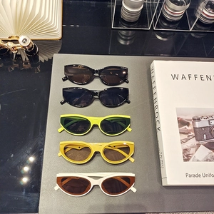 Detailed top view of five stylish cat-eye sunglasses in various colors on a fashion desk