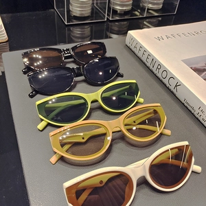 Five pairs of retro cat-eye sunglasses in various colors on an elegant display