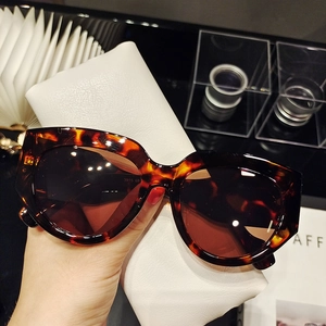Detail of tortoiseshell rectangular sunglasses with thick frame and specs on temple