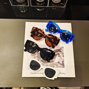 Retro thick-frame cat-eye sunglasses set in black, white, tortoiseshell, and blue