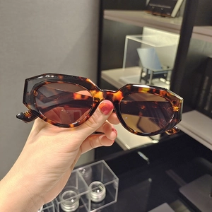 Macro detail of tortoiseshell cat-eye sunglasses with brown lenses and geometric cut edges