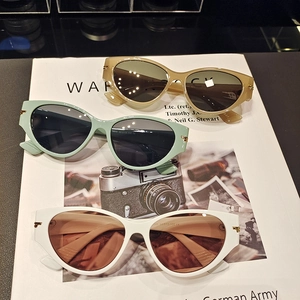 Chic cat-eye sunglasses set in beige, mint, and white with golden metal hinges