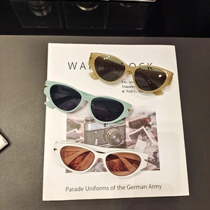 Chic cat eye sunglasses in beige and mint green set on a fashion magazine