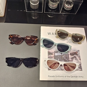 Fashionable oversized cat eye sunglasses in five colors on a magazine and leather surface