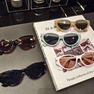 Close-up of five colorful cat-eye sunglasses with detailed size specs on inner temple