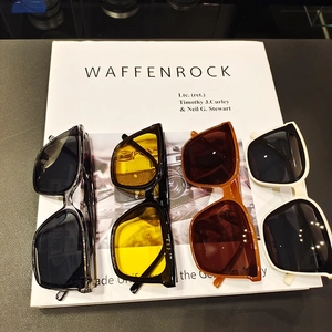 Macro shot of stylish square oversized sunglasses in transparent grey, amber, and cream colors