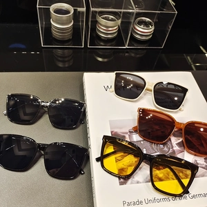 Flat lay of five assorted square oversized sunglasses with various frame and lens colors