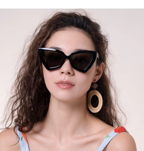 Gros plan sur des lunettes de soleil œil de chat noires portées par un mannequin en été