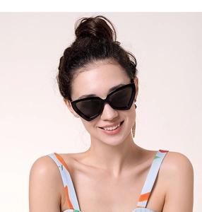 Détail d'un mannequin portant des lunettes de soleil œil de chat triangulaires noires