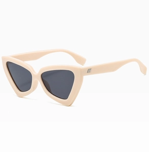 Détail de lunettes de soleil œil-de-chat crème avec rayures métalliques sur la branche