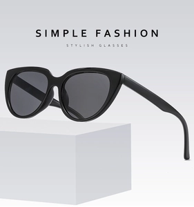 Close-up of black cat-eye sunglasses on a white pedestal with professional lighting