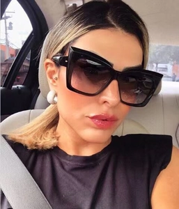 Nahaufnahme einer schwarzen Cat-Eye-Sonnenbrille mit Verlaufsgläsern an einem Modell