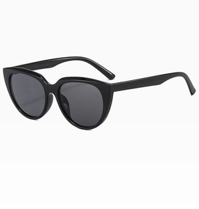 Detail view of glossy black cat-eye sunglasses with dark grey UV protective lenses