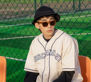 Style urbain en extérieur avec chemise de baseball crème, logo et lunettes de soleil