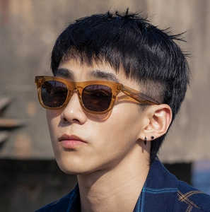 Gros plan de lunettes de soleil carrées ambre stylées avec rivets métalliques sur mannequin