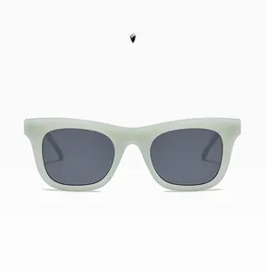 Détail de lunettes de soleil carrées bleu gelée mat avec des verres gris foncé tendance