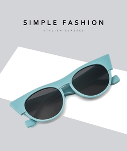Detailed view of mint green cat eye sunglasses with grey lenses and stylish frame
