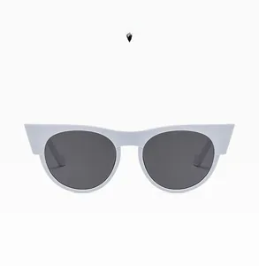 Detailed close-up of white cat-eye sunglasses with dark grey lenses on white background