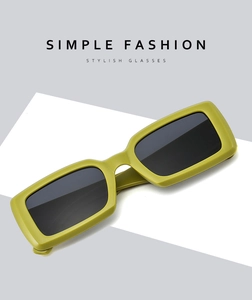 Detailed view of matte avocado green rectangular sunglasses on a modern display pedestal