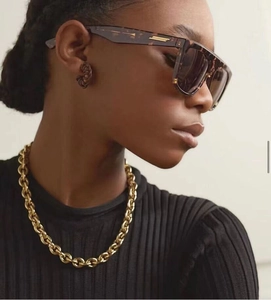 Detail of vintage tortoiseshell square sunglasses with gold metal temples and chunky chain