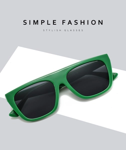 Detailed view of glossy green oversized square sunglasses with dark tinted lenses