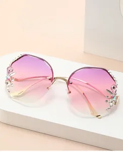 Detail view of purple gradient frameless sunglasses with gold metal arms and rhinestones