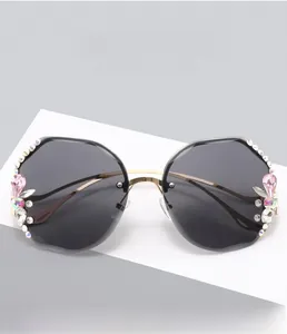 Detail of rimless sunglasses with pink teardrop crystals and gold metal temples