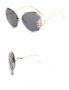 Detail view of rimless sunglasses with pink rhinestones and gold wavy metal temples