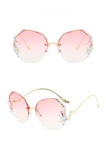 Detail of frameless gradient pink sunglasses with side rhinestones and gold temples