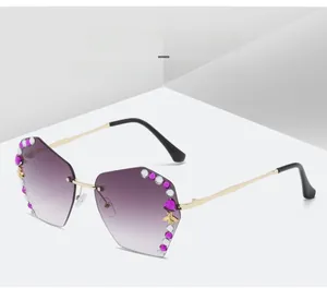 Detail of purple gradient rimless sunglasses with rhinestone border and gold bee accent