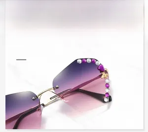Detail of gradient lenses with crystal rhinestones and golden bee motif on rimless sunglasses