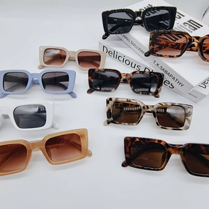 Flat lay of retro rectangle sunglasses in various colors on a white background