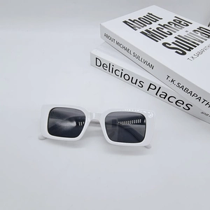 Flat lay of white rectangle retro sunglasses on books with UV protective dark lenses