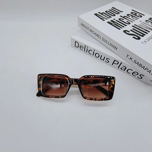 Detail shot of vintage rectangle tortoiseshell sunglasses with brown lenses on white background