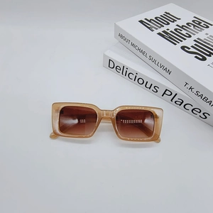 Detail view of vintage translucent amber rectangle sunglasses on books with brown lenses